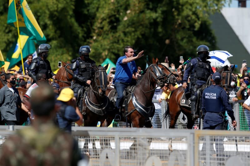 Brazil's President Jair Bolsonaro rides a horse during a meeting with supporters protesting in his favor, amid the coronavirus disease (COVID-19) outbreak, in Brasilia