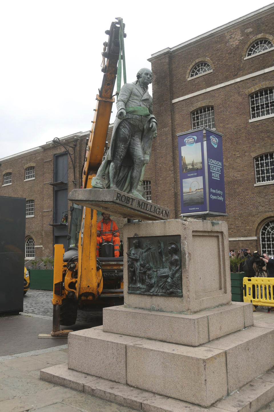 Workers take down a statue of slave owner Robert Milligan at West India Quay, east London, Tuesday, June 9, 2020, after a protest saw anti-racism campaigners tear down a statue of a slave trader in Bristol. London's mayor says statues of imperialist figures could be removed from the city's streets, in the latest sign of change sparked by the death of George Floyd. London Mayor Sadiq Khan says he is setting up a commission to ensure monuments reflect the city's diversity. (Yui Mok/PA via AP)