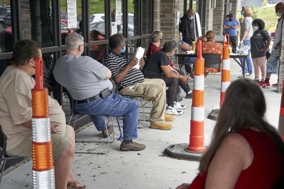 FILE - In this July 15, 2020, file photo, job seekers exercise social distancing as they wait to be called into the Heartland Workforce Solutions office in Omaha, Neb. The extra $600 in weekly unemployment benefits has expired, the federal eviction moratorium has ended and federal money to help businesses retain workers has grown lean. Meanwhile, the pandemic rages on and there is no consensus from Washington on another relief package. (AP Photo/Nati Harnik, File)