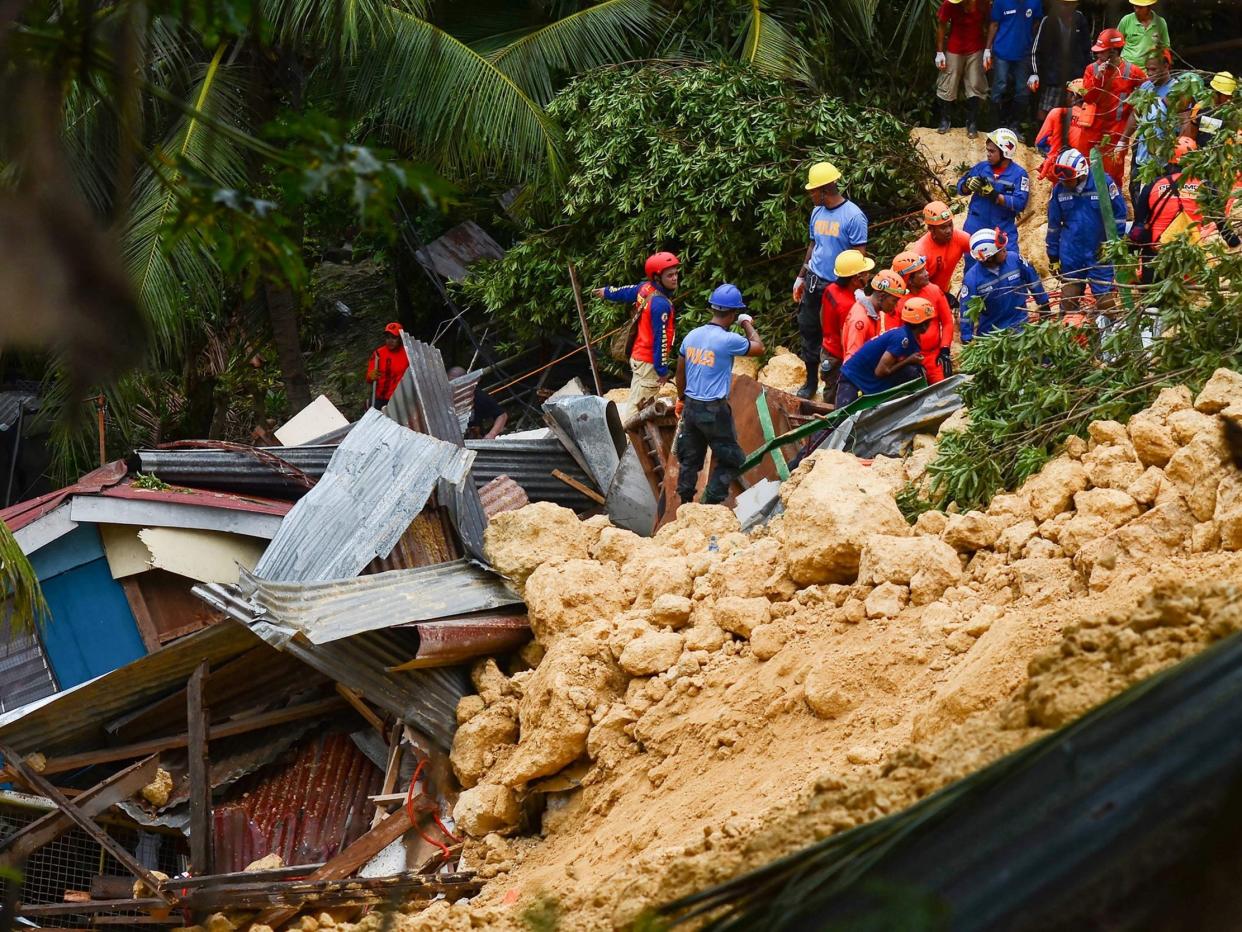 Rescuers search for survivors at the landslide site on the popular tourist island of Cebu: Getty