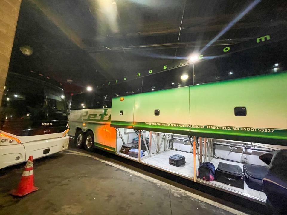 A peter pan bus with the luggage storage locker open.