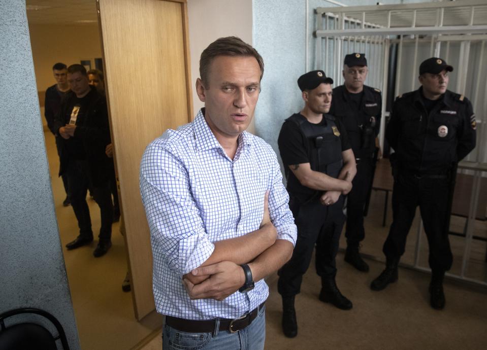 Russian opposition activist Alexei Navalny, center, stands in a court before a hearing in Moscow, Russia, Monday, July 1, 2019. A Moscow court jailed Russian opposition leader Alexei Navalny for 10 days on Monday after finding him guilty of breaking the law when he took part in a street demonstration last month. (AP Photo/Pavel Golovkin)