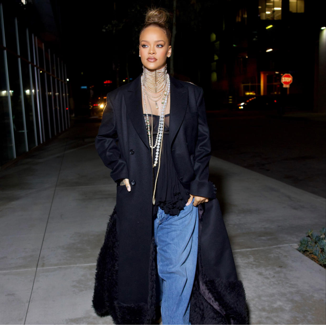  Rihanna in lingerie, blue jeans, pearl necklaces, and a black maxi coat. 