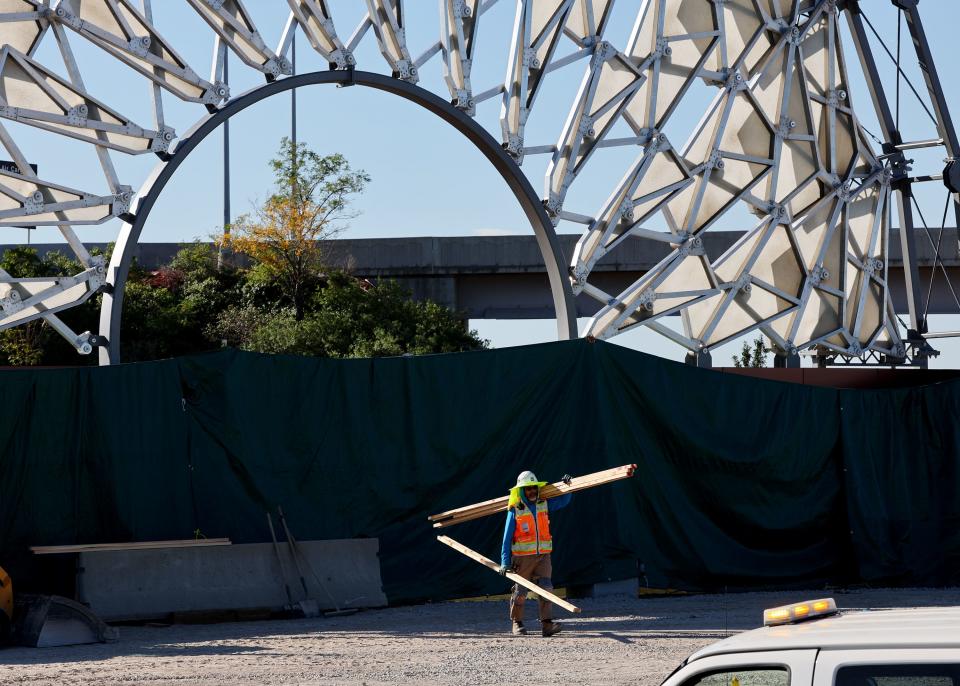 A worker carries materials as the Hoberman Arch has been reassembled in its new home at the Salt Lake City International Airport in Salt Lake City on Monday, Aug. 28, 2023. | Scott G Winterton, Deseret News