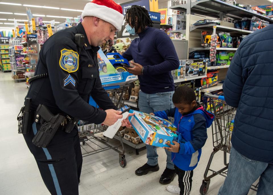 Buckingham Township Police Cpl. Steve Thomas helps Jeremiah McClain, 4, of Doylestown, with a toy he selected during Plumstead Township Police Department's 5th annual Shop with a Cop event at Walmart in Hilltown Township on Tuesday, December 8, 2021. Funded by community donations, the program paired law enforcement officers from 11 local departments with more than 100 kids to help them shop for presents for themselves and their families.