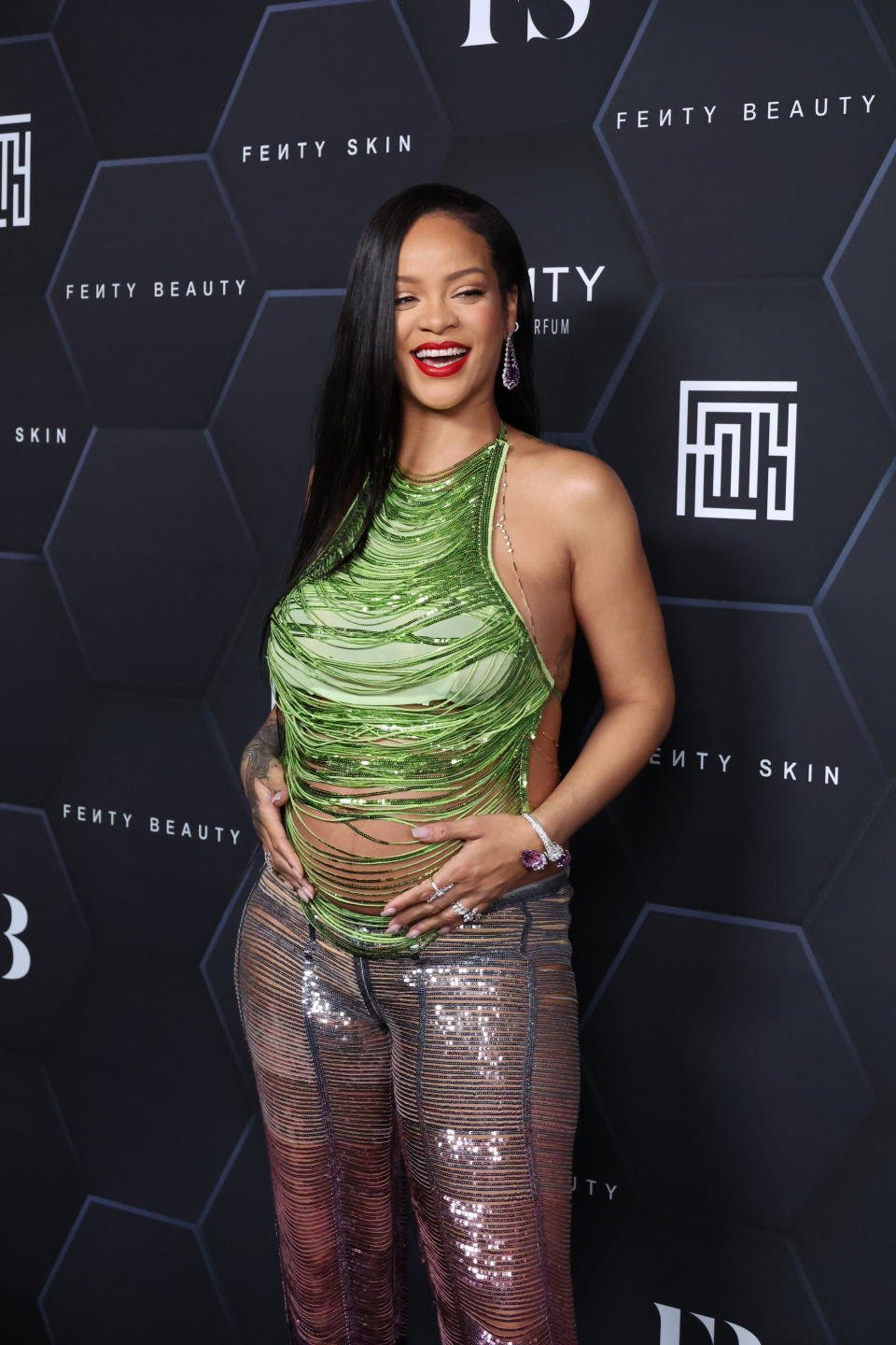 Rihanna cradler her baby bump while posing on the red carpet. She made the bump-baring trend popular again in 2022. (Getty Images)