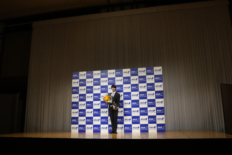 Two-time Olympic champion Yuzuru Hanyu of Japan, poses with flowers after a press conference in Tokyo, Tuesday, July 19, 2022. Hanyu is stepping away from competitive figure skating, he said Tuesday. (AP Photo/Shuji Kajiyama)