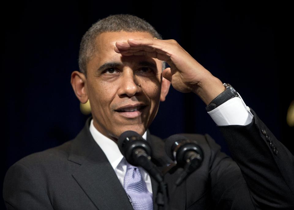 President Barack Obama shields his eyes in attempt to see a heckler who interrupted his speech during his speech at the general session of the Democratic National Committee winter meeting in Washington, Friday, Feb. 28, 2014. (AP Photo/Pablo Martinez Monsivais)