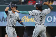 Seattle Mariners' Dylan Moore (25) celebrates his two-run home run with J.P. Crawford (3) during the second inning against the Texas Rangers in a baseball game Friday, May 7, 2021, in Arlington, Texas. (AP Photo/Richard W. Rodriguez)