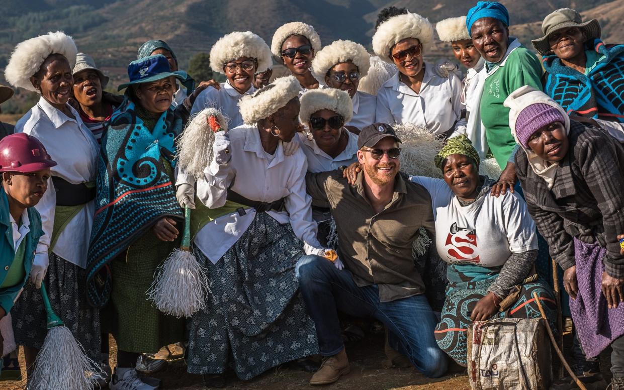 Prince Harry takes a picture with members of the Leribe community