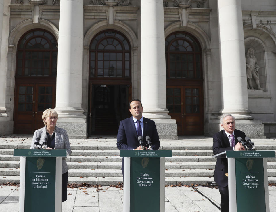 Irish Prime Minister Leo Varadkar, center, along with Government ministers Richard Bruton, right, and Heather Humphreys at a press briefing outside government buildings in Dublin, Wednesday, Oct. 2, 2019. Britain has sent its proposals for a Brexit deal to leaders of the European Union, with Prime Minister Boris Johnson urging "rapid negotiations towards a solution." The proposals focus on maintaining an open border between the U.K.'s Northern Ireland and EU member Ireland, the key sticking point in getting a Brexit deal finalized. (Brian Lawless/PA via AP)