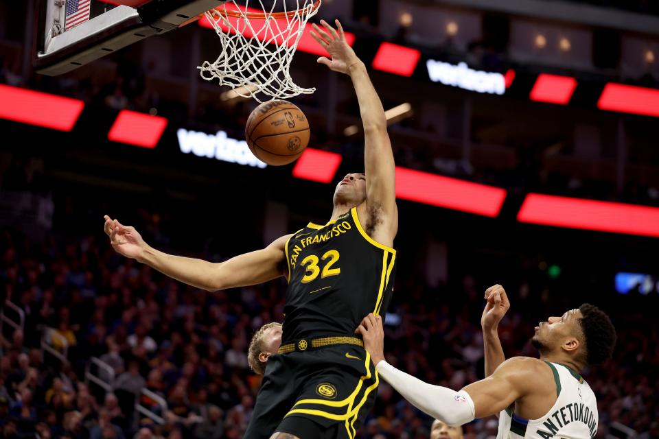 Trayce Jackson-Davis of the Warriors dunks on the Bucks' Giannis Antetokounmpo on Wednesday night.