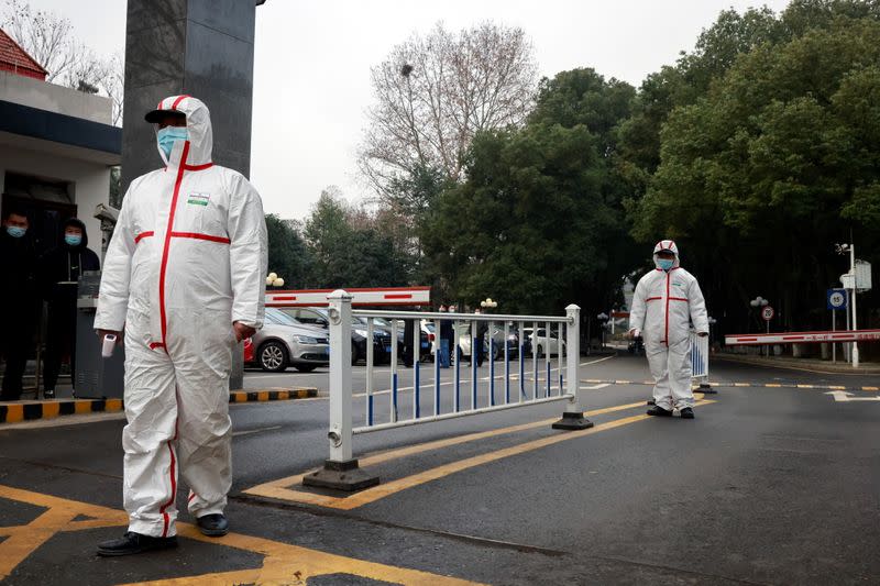 Security personnel look on during the visit by members of the WHO team tasked with investigating the origins of the coronavirus disease (COVID-19), at the Hubei provincial center for disease control in Wuhan