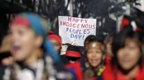 <p>A sign is held aloft during an Indigenous Peoples Day march Monday, Oct. 9, 2017, in Seattle, Wash. (Photo: Elaine Thompson/AP) </p>