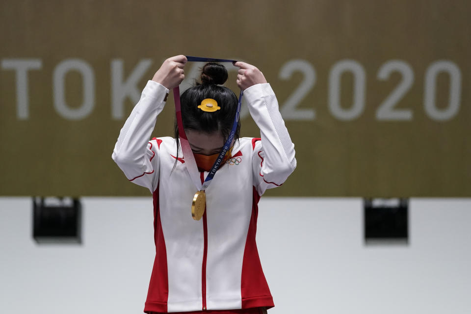 Yang Qian, of China, puts her gold medal on after winning the women's 10-meter air rifle at the Asaka Shooting Range in the 2020 Summer Olympics, Saturday, July 24, 2021, in Tokyo, Japan. (AP Photo/Alex Brandon)