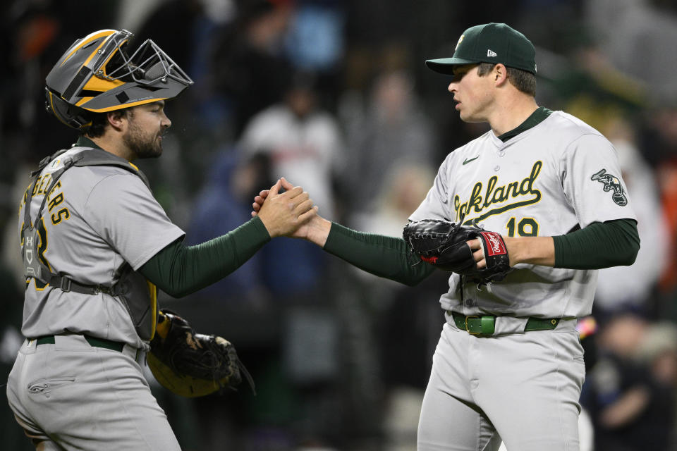 Oakland Athletics relief pitcher Mason Miller, right, celebrates with catcher Shea Langeliers, left, after a baseball game against the Baltimore Orioles, Friday, April 26, 2024, in Baltimore. (AP Photo/Nick Wass)