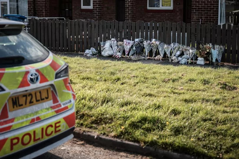 Police at the scene along with floral tributes