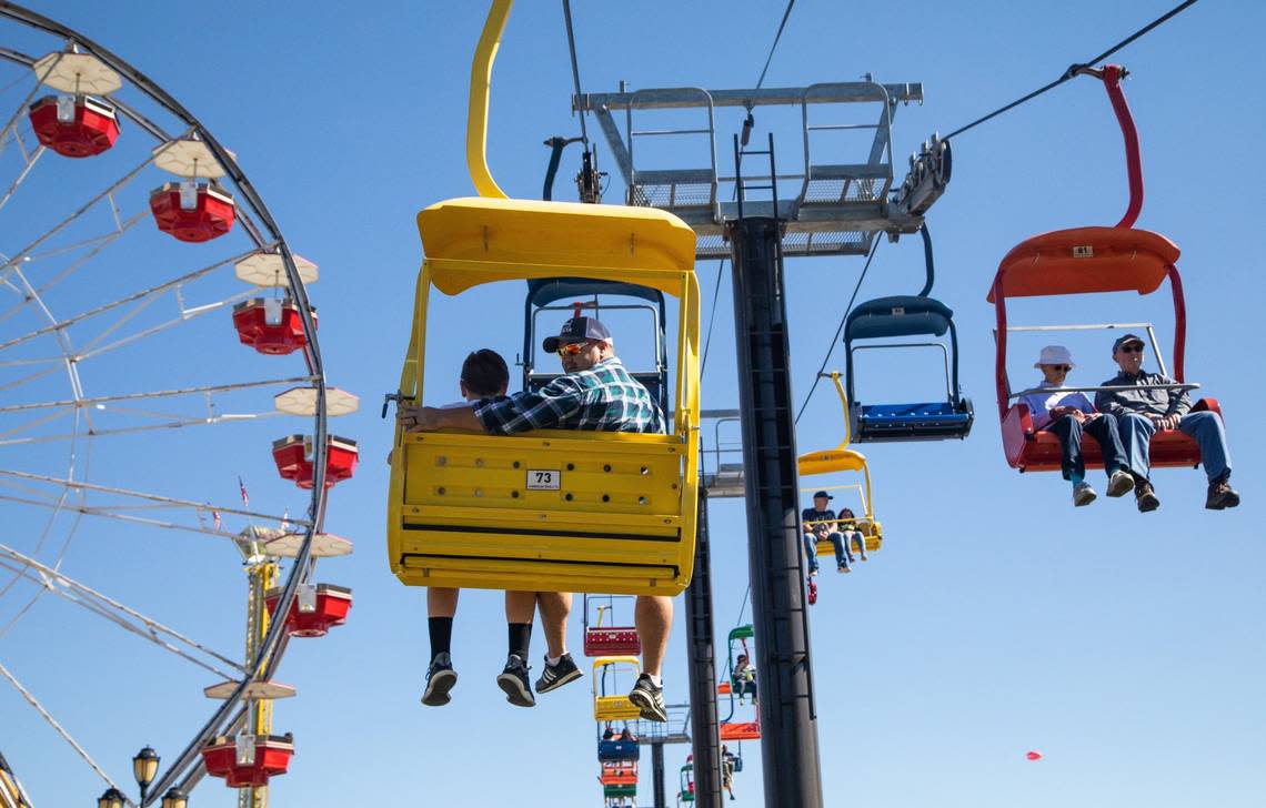 Shawn Rychcik and his son Ajay, 11, of Apex, left, ride the State Fair Flyer on opening day of the NC State Fair Friday, Oct. 12, 2018.