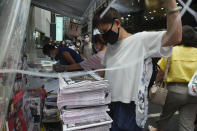 A vender adjusts a stack of last issue of Apple Daily at a newspaper booth at a downtown street in Hong Kong, Thursday, June 24, 2021. Hong Kong's sole remaining pro-democracy newspaper has published its last edition. Apple Daily was forced to shut down Thursday after five editors and executives were arrested and millions of dollars in its assets were frozen as part of China's increasing crackdown on dissent in the semi-autonomous city. (AP Photo/Vincent Yu)