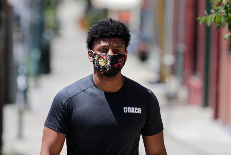 Sharaka Berry wears a mask as he walks on Brady Street on Milwaukee's east side Monday.