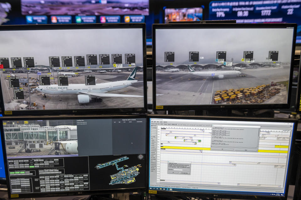 Displays at the Integrated Airport Center show video feeds of planes at Hong Kong International Airport in Hong Kong, Friday, Nov. 25, 2022. Hong Kong on Friday launched its newly-built third runway, which is expected to be part of a three-runway system in 2024 that will boost the city's status as an aviation hub. (AP Photo/Vernon Yuen)