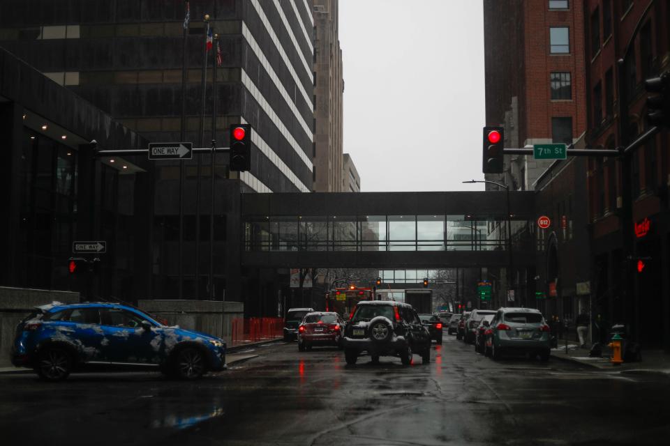 Cars covered with snow drive turn onto Locust Street in downtown Des Moines on Tuesday, Nov. 15, 2022.