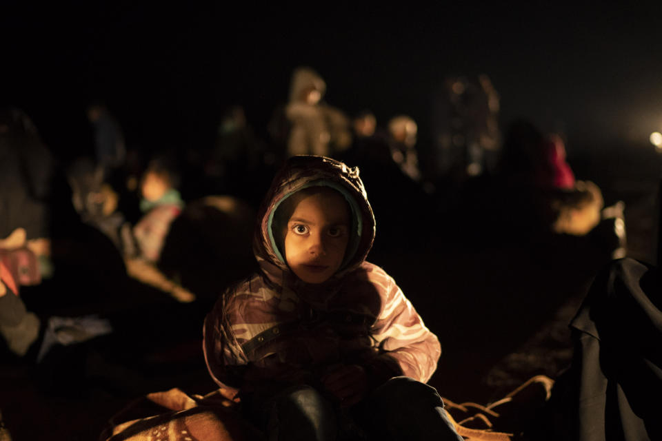 A girl evacuated out of the last territory held by Islamic State militants waits after being screened by U.S.-backed Syrian Democratic Forces (SDF) in the desert outside Baghouz, Syria, Monday, Feb. 25, 2019. (AP Photo/Felipe Dana)