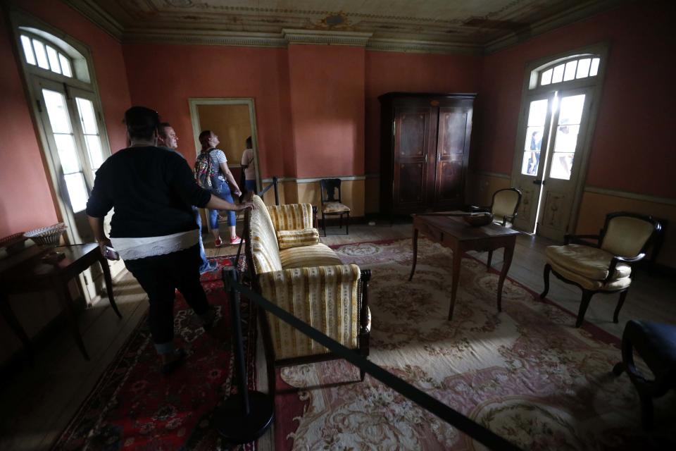 FILE- In this July 14, 2017 file photo, visitors walk through the Whitney Plantation in Edgard, La. The Whitney, which documents slavery at a pre-Civil War plantation near New Orleans, draws tens of thousands of visitors annually and is known for discussing topics that other tourist plantations ignore. Yet even its entry in the National Register, completed in 1992 before the current owner purchased it, doesn't mention the slaves who toiled there.(AP Photo/Gerald Herbert, File)