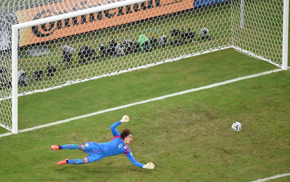 Mexico's goalkeeper Guillermo Ochoa dives to stop the ball during their 2014 World Cup Group A soccer match against Brazil at the Castelao arena in Fortaleza June 17, 2014. (Francois Xavier Marit/Reuters)