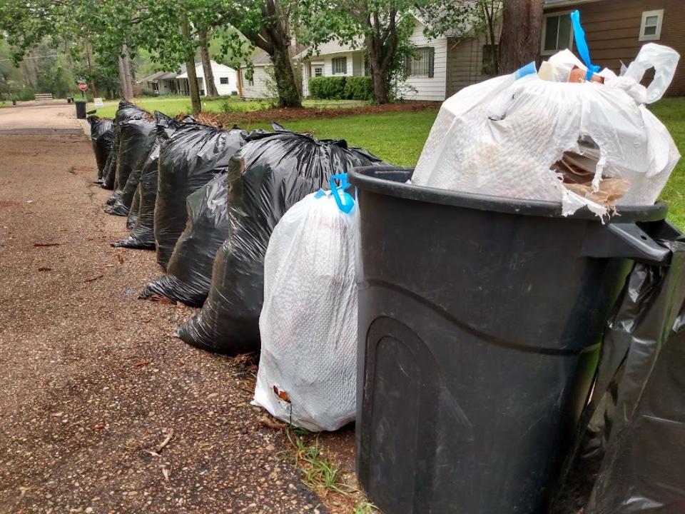 Piles of bagged household and yard waste remain uncollected on Meadow Heights Drive in Jackson Monday morning.