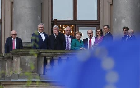 Leader of the German Green Party Cem Ozdemir and leader of the Christian Democratic Union of Germany (CDU) Angela Merkel accompanied by the politicians of their parties are seen on the balcony of German Parliamentary Society offices prior to the exploratory talks about forming a new coalition government held by CDU/CSU in Berlin, Germany, October 18, 2017. REUTERS/Hannibal Hanschke