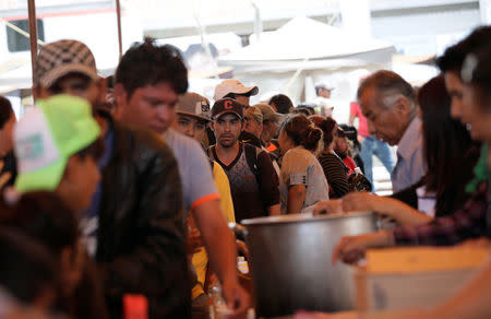 Central American migrants moving in a caravan through Mexico toward the U.S. border, stand in line for food at a shelter set up for them by the Catholic church, in Puebla, Mexico April 6, 2018. REUTERS/Henry Romero