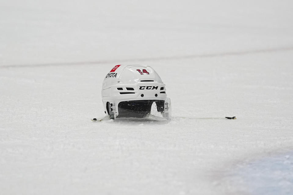 A Minnesota Wild helmet sits on the ice during the second period of an NHL hockey game against the Colorado Avalanche Tuesday, April 9, 2024, in Denver. (AP Photo/Bart Young)