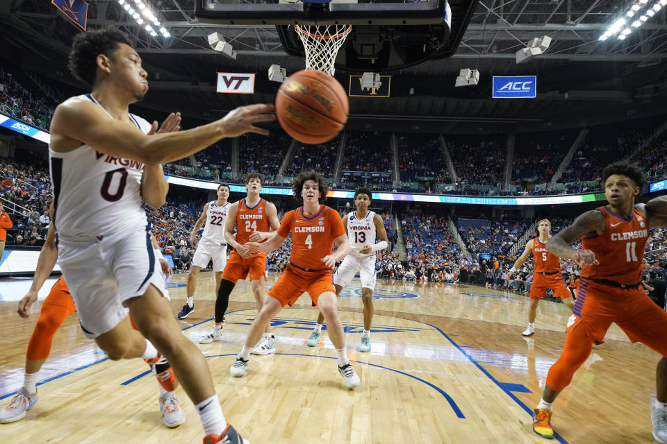 Virginia guard Kihei Clark (0) saves the ball as he goes out of bounds against Clemson during the first half of an NCAA college basketball game at the Atlantic Coast Conference Tournament in Greensboro, N.C., Friday, March 10, 2023. (AP Photo/Chuck Burton)