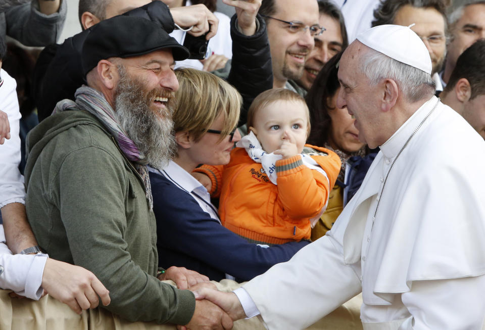 Pope Francis greets faithful as he arrives at the Don Gnocchi Foundation for assistance to disabled and elderly to celebrate the rite of the washing of the feet, in Rome, Thursday, April 17, 2014. Pope Francis has washed the feet of 12 elderly and disabled people — women and non-Catholics among them — in a pre-Easter ritual designed to show his willingness to serve like a "slave." Francis' decision in 2013 to perform the Holy Thursday ritual on women and Muslim inmates at a juvenile detention center just two weeks after his election helped define his rule-breaking papacy. It riled traditionalist Catholics, who pointed to the Vatican's own regulations that the ritual be performed only on men since Jesus' 12 apostles were men. The 2014 edition brought Francis to a center for the elderly and disabled Thursday. Francis kneeled down, washed, dried and kissed the feet of a dozen people, some in wheelchairs. He said the ritual is a gesture of "a slave's service." (AP Photo/Riccardo De Luca)