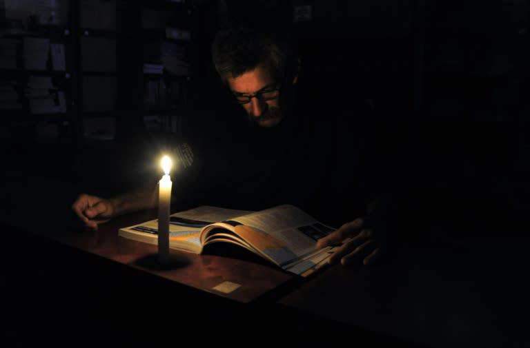 A man reads in candlelight during a power cut in the border state of San Cristobal, Venezuela