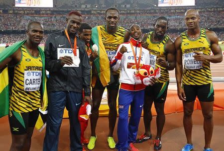 Jamaica's team for the men's 4 x 100 metres relay Nesta Carter, Asafa Powell, Nickel Ashmeade and Usain Bolt pose with Mo Farah of Britain, gold medal, Caleb Mwangangi Ndiku of Kenya, silver medal, and Hagos Gebrhiwet of Ethiopia, bronze medal, after the podium ceremony for the men's 5,000 metres event during the during the 15th IAAF World Championships at the National Stadium in Beijing, China, August 29, 2015. REUTERS/Damir Sagolj