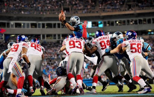 Cam Newton of the Carolina Panthers dives over the New York Giants defense to score a touchdown on September 20, 2012 in Charlotte, North Carolina. The Giants won 36-7