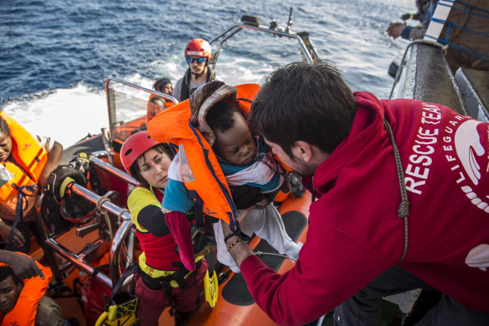 FILE - In this Friday, Dec. 21, 2018 file photo, a baby is loaded into the rescue vessel of the Spanish NGO Proactiva Open Arms, after being rescued in the Central Mediterranean Sea at 45 miles (72 kilometers) from Al Khums, Libya. A judge in Sicily has dropped an investigation against two member of the Spanish aid group Proactiva Open Arms deriving from a tense high-seas standoff last year when the crew refused to hand over 218 migrants rescued at sea to the Libyan coast guard. Proactiva welcomed the decision to drop the investigation into criminal association and aiding illegal migration Wednesday, calling it ‘’an additional step toward the truth.’’ The group stated that it has always operated according to international roles. (AP Photo/Olmo Calvo, File)