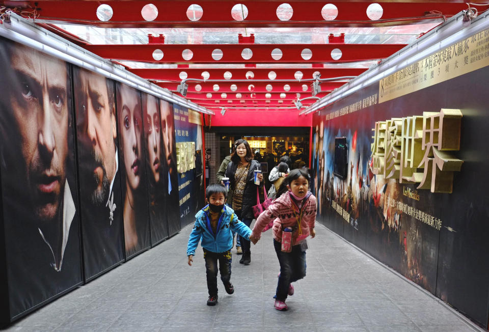 In this Feb. 7, 2013 photo, movie goers head to a popular theater complex as the Chinese New Year nears in Taipei, Taiwan. Tens of millions of film fanatics are entering theaters around Asia during the long Lunar New Year holiday, but Hollywood can’t count on them to boost the box office for its mostly serious Oscar nominees. Even with the Academy Awards buzz at a peak barely two weeks before the ceremony, patrons are opting for lighter fare. (AP Photo/Wally Santana)