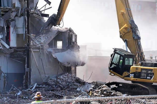 PHOTO: A worker watches debris fall during demolition at the site of a building collapse, June 12, 2023, in Davenport, Iowa. (Charlie Neibergall/AP)