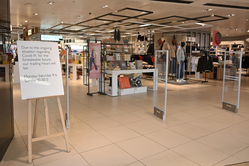 A sign at the entrance to the John Lewis store in Birmingham city centre shows their new opening hours, as they remain open for business, in central England on the morning of March 21, 2020, a day after the British government said it would help cover the wages of people hit by the coronavirus outbreak as it tightened restrictions to curb the spread of the disease. (Photo by JUSTIN TALLIS / AFP) (Photo by JUSTIN TALLIS/AFP via Getty Images)