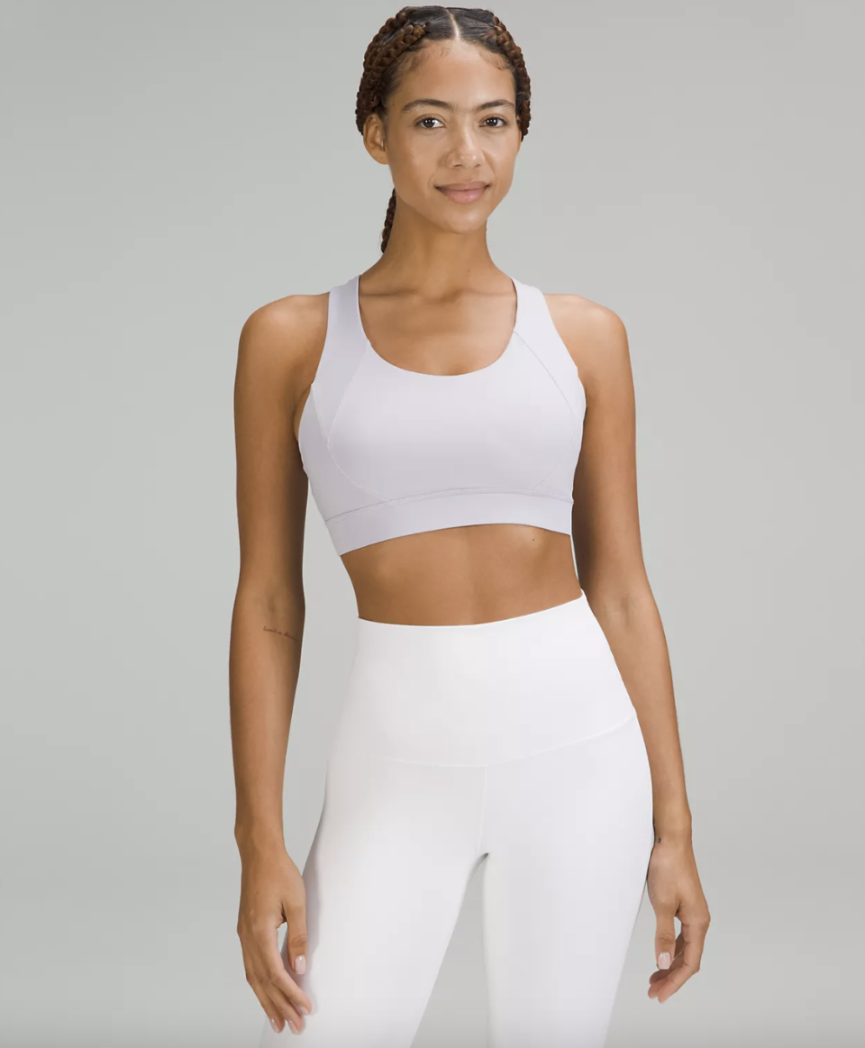 A woman wearing Free to Be Elevated Bra in white with white leggings. (Photo via Lululemon)