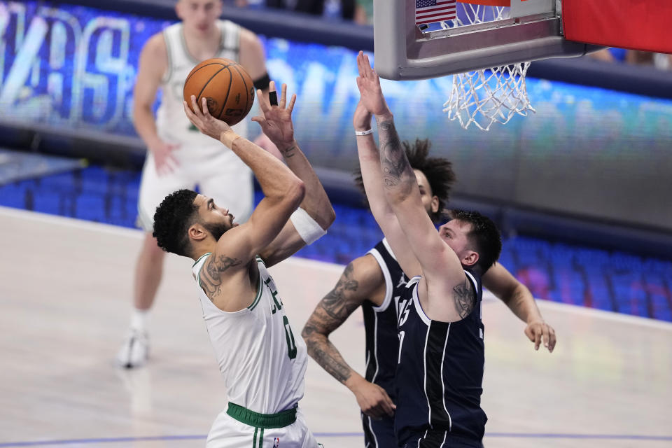 Boston Celtics forward Jayson Tatum (0) shoots against Dallas Mavericks guard Luka Doncic, right, during the first half in Game 4 of the NBA basketball finals, Friday, June 14, 2024, in Dallas. (AP Photo/Sam Hodde)