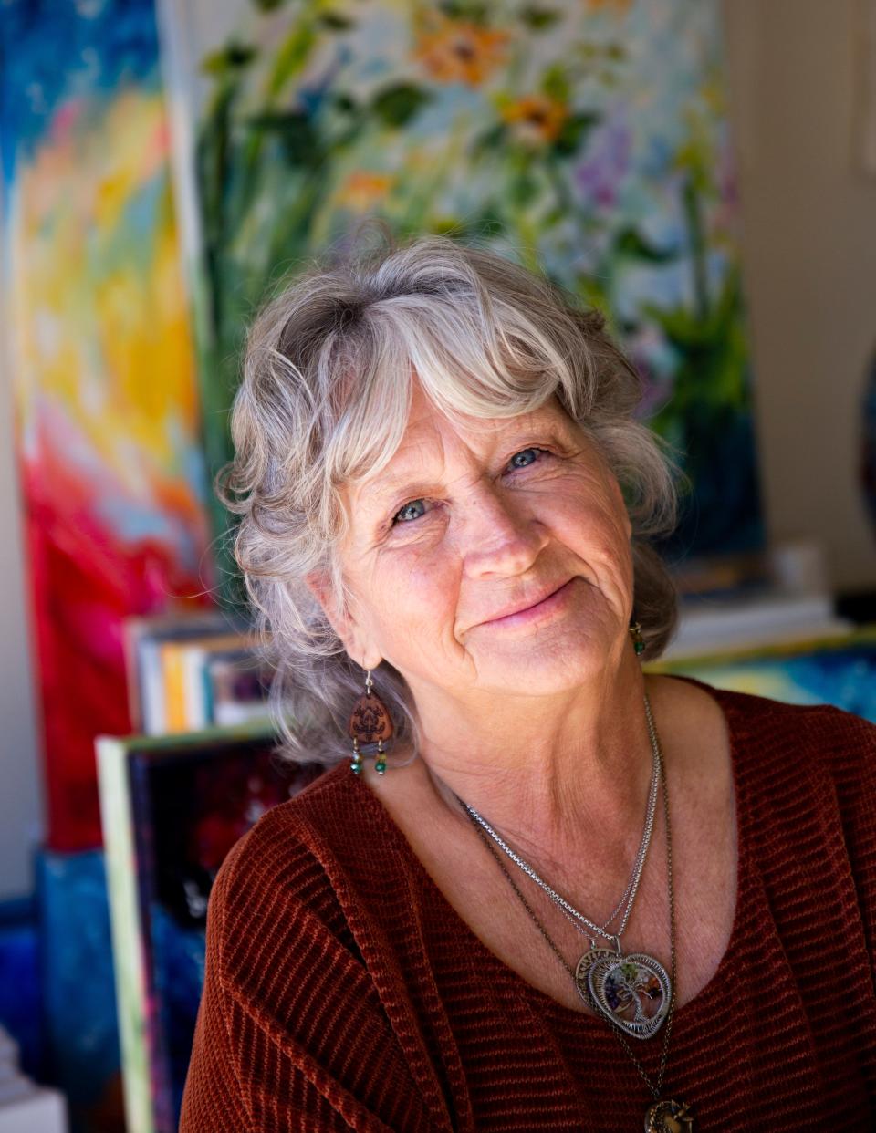 Local artist Vicki Crouse Henley poses for a portrait next to her paintings on Tuesday, Jan. 16, 2024, at her home. The LCIFF board announced that she will be this year’s poster artist for the Las Cruces International Film Festival.