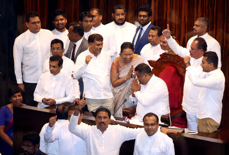 Parliament member Arundika Fernando who is backing newly appointed Prime Minister Mahinda Rajapaksa sits on the speakers chair to block Speaker Karu Jayasuriya during the parliament session in Colombo, Sri Lanka November 16, 2018. REUTERS/Stringer