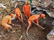 This photograph provided by India's National Disaster Response Force (NDRF) shows NDRF personnel trying to rescue those buried under the debris after a mudslide in Noney, northeastern Manipur state, India, Thursday, June 30, 2022. (National Disaster Reponse Force via AP)