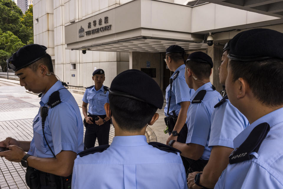 Police officers stand guard outside the High Court ahead of the hearing for an injunction to ban the 2019 protest song "Glory to Hong Kong" in Hong Kong, Friday, July 21, 2023. (AP Photo/Louise Delmotte)