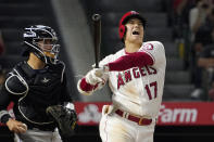 Los Angeles Angels' Shohei Ohtani, right, yells as he strikes out as Colorado Rockies catcher Dom Nunez stands at the plate during the seventh inning of a baseball game Monday, July 26, 2021, in Anaheim, Calif. (AP Photo/Mark J. Terrill)