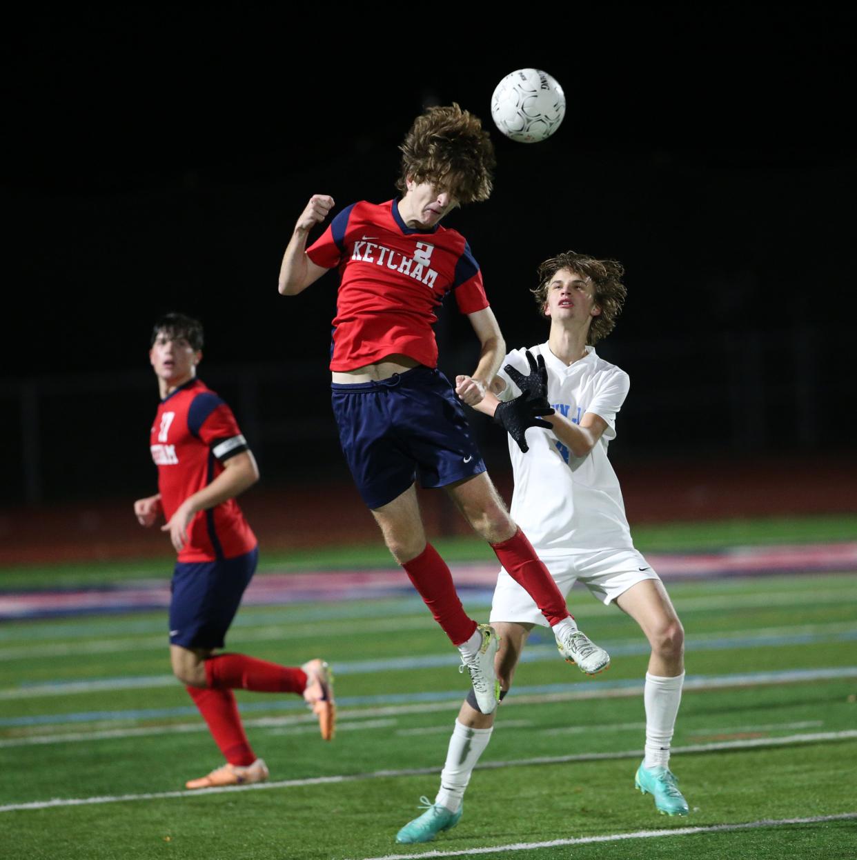 Ketcham's Travis Delaney headers the ball away from John Jay's Gabriel Koscik during a Section 1 quarterfinal on October 23, 2023.